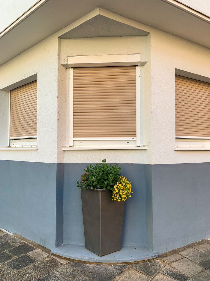 Corner view of a modern building with a planter, showcasing urban architecture and simple decoration.